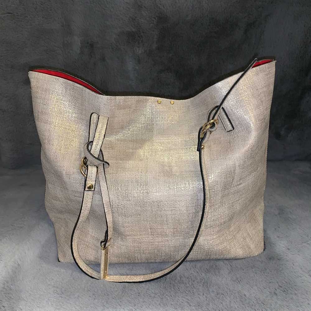 Cream and gold colored purse with red interior